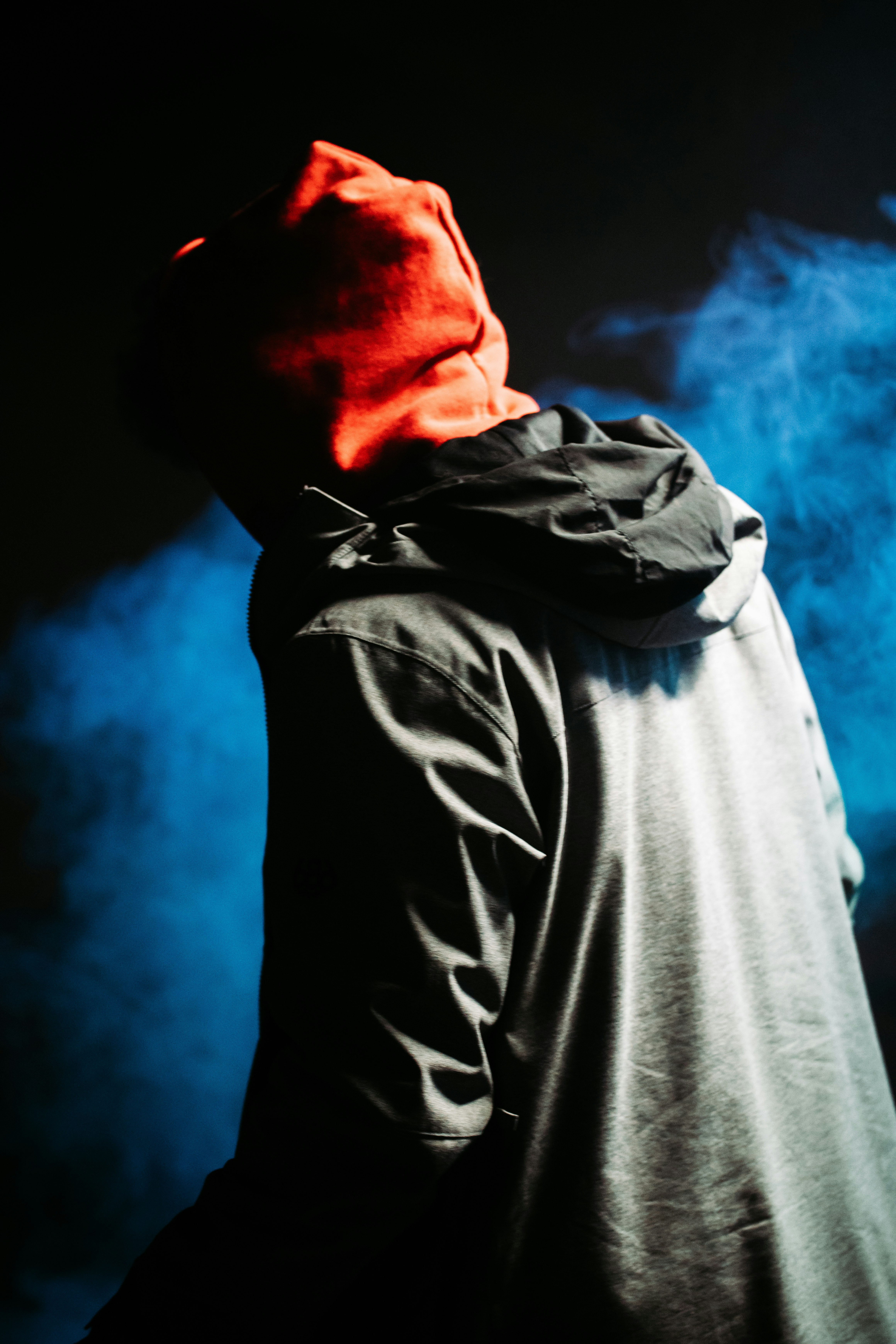 man in gray hoodie with blue smoke in his face